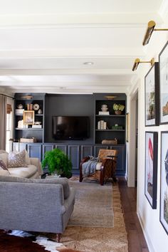 a living room filled with furniture and pictures on the wall