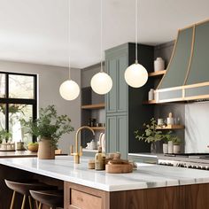 a kitchen with green cabinets and marble counter tops, hanging lights over the island area