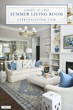 a living room with white furniture and blue accents