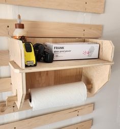 a wooden shelf with some toilet paper on top of it and a yellow toy car