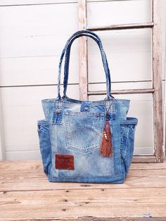 a blue jean purse sitting on top of a wooden bench