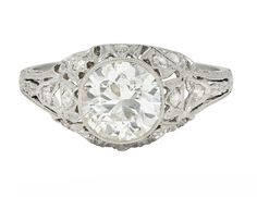 an antique style diamond ring with filigrees on the shoulders and sides, set in