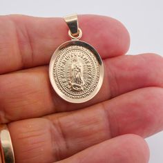 Our lady of guadalupe medal 14k yellow gold is the perfect way to show your special someone how much they mean to you! This classic and sturdy Genuine solid 14k solid gold medal is a work of art and truly unique while still appealing to everyone. It conveys the unconditional love and protection of Our Lady of Guadalupe beautifully while also being practical and long-lasting. This our lady of guadalupe medal 14k yellow gold is crafted with only the highest quality materials, including 14K genuine Oval Yellow Gold Jewelry With Our Lady Of Guadalupe, 14k Gold Our Lady Of Guadalupe Necklace, Gold Our Lady Of Guadalupe Round Pendant Necklace, Gold Our Lady Of Guadalupe Medallion, Virgin Mary Necklace, Spiritual Jewelry: Our Lady Of Guadalupe Round Pendant, Beautiful Symbols, Mexican Culture, First Communion