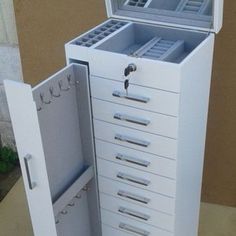 an open jewelry box sitting on top of a table next to a door and window