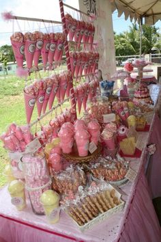 a pink table topped with lots of desserts and candy bar items on top of it