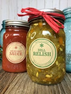 three jars filled with pickles sitting on top of a wooden table next to each other