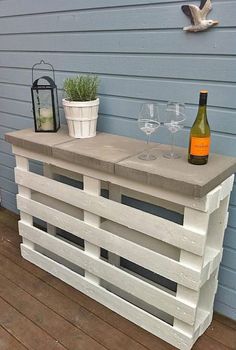 an outdoor bar made out of wooden pallets with wine glasses and bottles on top