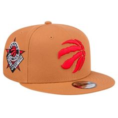 the toronto raptors snap back hat is tan with red embroidered on the front and side