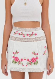 For a busy vacation itinerary, the Jolene mini skirt has chic, everyday appeal. Featuring beautiful pink floral embroidery and lace trims, this white cotton mini skirt can be styled as a co-ord skirt set when paired with the Jolene Embroidered Top. Fit Notes The Jolene Embroidered Mini Skirt is fitted at the waist and flares out slightly through the hip. We suggest taking your regular size. Style Notes Fully lined Functional skinny tie closure at the left side seam Fabric + Care Crafted in 100% Cotton Lining is made of 100% Cotton Cold hand wash, do not bleach, tumble dry low Do not dry clean Embroidered Mini Skirt Outfit, Cotton Mini Skirt, Vacation Itinerary, Miniskirt Outfits, Top Skirt Set, Swimwear Sets, Lace Trims, Top Pants Set, Strapless Tops