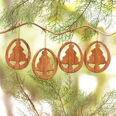 three wooden ornaments hanging from a tree branch