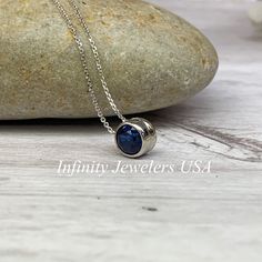 "The pendant pictured is lab created blue sapphire #5871 -Approximate total carat weight: approx. .80ctw diamond equivalent -Center Stone Size: 6mm - approx. .80ct diamond equivalent -Center Stone Shape: round -Gem Type: lab created sapphire -Stone Clarity: VS2 -Stone Color: Blue -Moh's Scale: 9 hardness -Metal Type and Purity: 14k white gold -Setting: bezel set floating necklace -Chain: 18\" delicate 14k gold chain / heavier option with lobster claw available (use dropdown to select) -Country o Blue Diamond Cut Jewelry With Round Stone, Blue Diamond Cut Round Stone Jewelry, Blue Round Pendant Jewelry For Anniversary, Blue Round Stone Diamond Cut Jewelry, Blue Sapphire Birthstone Necklace For Anniversary, Blue Bezel Set Jewelry For Anniversary, Blue Jewelry With Bezel Setting For Anniversary, Blue Round Birthstone Necklace For Anniversary, Polished Sapphire Jewelry With Round Stone