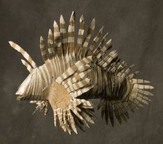 an animal made out of cardboard sitting on top of a black surface with white and brown strips