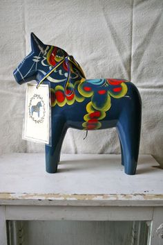 a blue horse figurine sitting on top of a white shelf