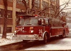 an old fire truck is parked on the side of the road in front of a building