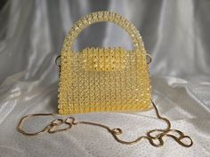 Handmade Crystal Yellow Beaded Bag with Golden-Toned Hardware This elegant handbag, crafted from crystal yellow beads, features golden-toned hardware and a 47-inch removable chain. The magnetic closure adds convenience and ease of use. Our bags are 100% handmade. Each bag is unique and crafted with love for our customers. It takes 3-5 days to create one bag. A perfect gift for women, friend, family member or loved one. Ideal for any celebration, event, wedding or birthday party. This unique and Yellow Beaded Party Bag, Luxury Gold Beaded Evening Bag, Elegant Yellow Beaded Bag, Gold Bags With Gold Beads For Gifts, Beads Bag, Crystal Yellow, Elegant Handbag, Beaded Bag, One Bag