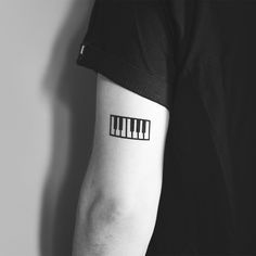 a black and white photo of a person's arm with piano keys on it