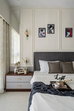 a bedroom with a bed, dresser and pictures on the wall above it's headboard