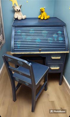 a blue desk and chair with a stuffed animal sitting on it's top shelf