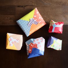 four folded pieces of paper sitting on top of a wooden table