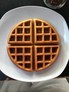 two waffles on a white plate with a glass of wine