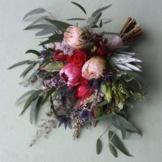 a bouquet of flowers and greenery on a table