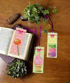 an open book sitting on top of a wooden table next to plants and other items