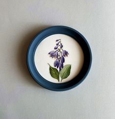 a blue and white plate with purple flowers on it