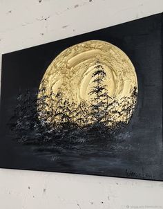 a black and gold painting hanging on the wall