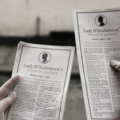 two people holding up newspapers with their hands