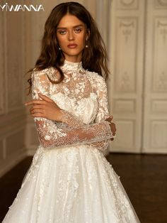 a woman in a white dress with long sleeves and lace on the top is posing