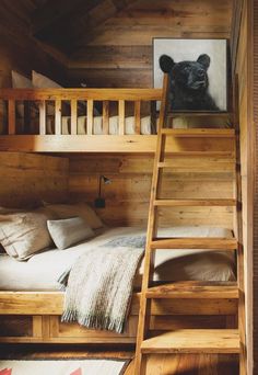 there is a bunk bed with a ladder to the bottom and a painting on the wall above it