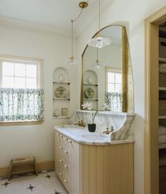 a bathroom with marble counter tops and gold fixtures