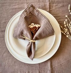 a plate with a napkin and some dried flowers on it