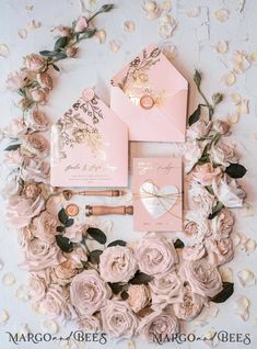 the wedding stationery is surrounded by pink flowers