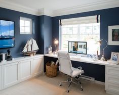 a home office with blue walls and white furniture, along with a sailboat mounted on the wall