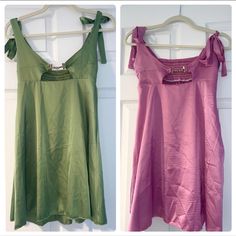 two dresses hanging up on a wall next to each other, one in green and the other in pink