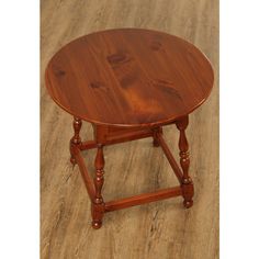 a small round wooden table sitting on top of a hard wood floor