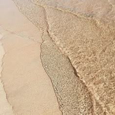 an aerial view of the beach with waves coming in and sand on the shore line