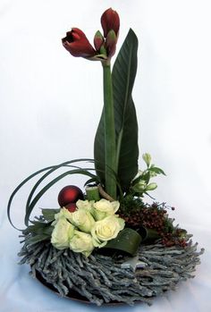 an arrangement of flowers and greenery in a bowl