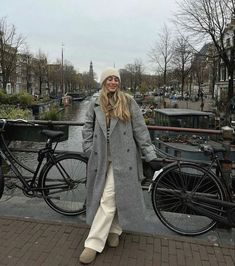 a woman standing next to a bike on a bridge