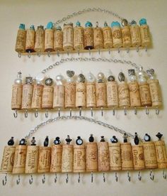 there are many wine corks hanging on the wall with metal hooks attached to them