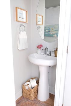 a white sink sitting under a bathroom mirror