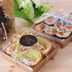 two boxes filled with pastries sitting on top of a wooden table