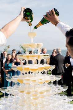 two people are pouring champagne into wine glasses