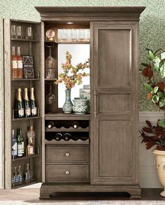 an armoire with wine bottles and glasses in it