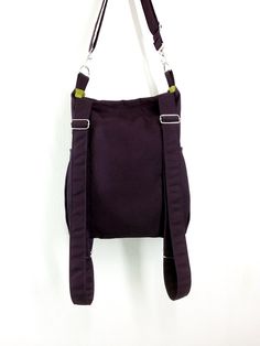 a purple purse hanging on the wall with straps around it's neck and shoulder