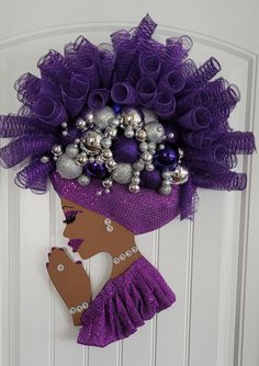 a door hanger decorated with purple and silver decorations