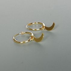 A PAIR of sterling silver hoops dipped in gold. Comes with a tiny crescent moon charm. The charm is multipurpose and can be used with a neck or bracelet chain too. Dimension: Hoop- 12x1 mm Charm- 4 x 9mm Drop length- 18 mm This piece is made of 925 hypoallergenic sterling silver. All my pieces are sent in a gift box. I can include a personal message from you if needed. You are welcome to contact me at... bhavnakwintra1956@gmail.com More hoops: https://www.etsy.com/your/shops/TheSilverGame/tools/ Moon Charm Hoop Earrings In Celestial Style, Celestial Hoop Earrings With Moon Charm, Celestial Round Hoop Earrings With Moon Charm, Minimalist Sterling Silver Hoop Earrings With Moon Charm, Adjustable Moon Charm Hoop Earrings, Adjustable Hoop Earrings With Moon Charm, Celestial Small Hoop Huggie Earrings, Small Hoop Celestial Earrings With Moon Charm, Celestial Small Hoop Earrings With Moon Charm