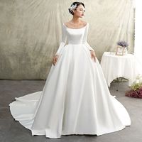 a woman in a white wedding dress standing next to a table with flowers on it