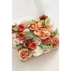 an arrangement of flowers in a white box